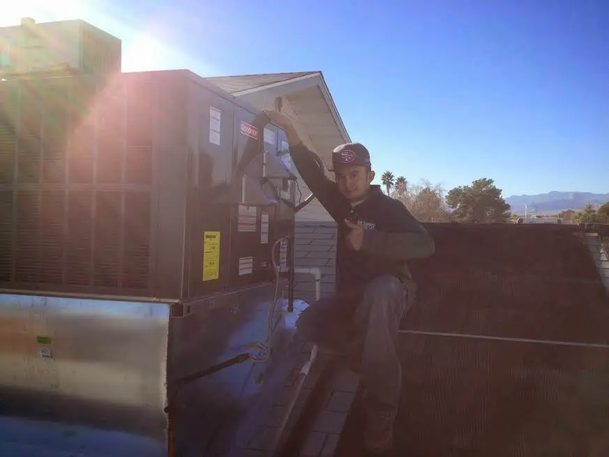 HVAC technician performing Air Duct Cleaning on a rooftop unit in Sallisaw